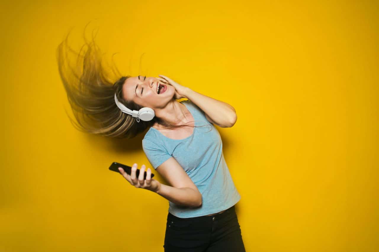 Imagem ostra uma mulher ouvindo música no celular.