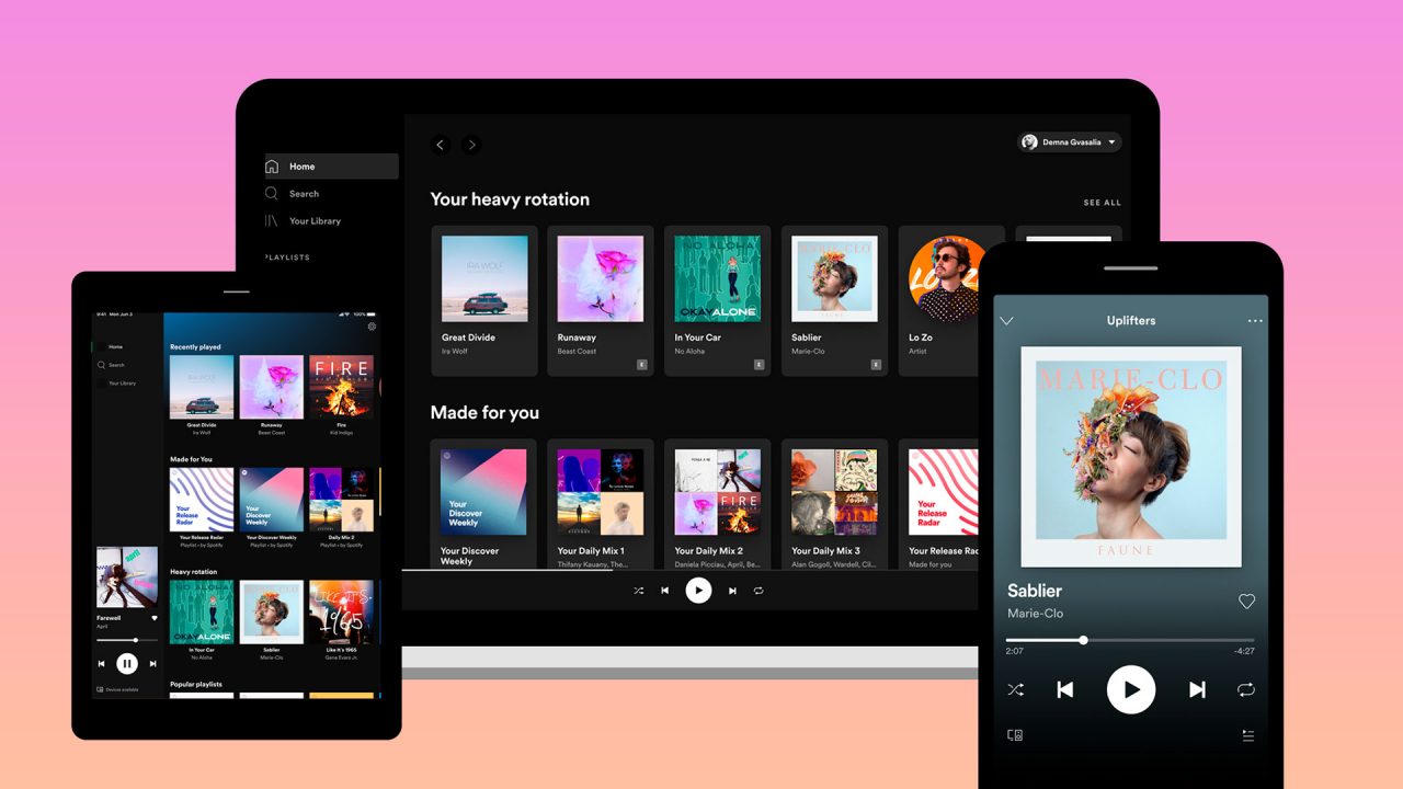 empresa planeja lançar stories em suas playlists - imagem mostra a tela inicial do Spotify em três dispositivos: um tablet, uma tela de computador e um celular. É possível ver capas de álbuns diversos.