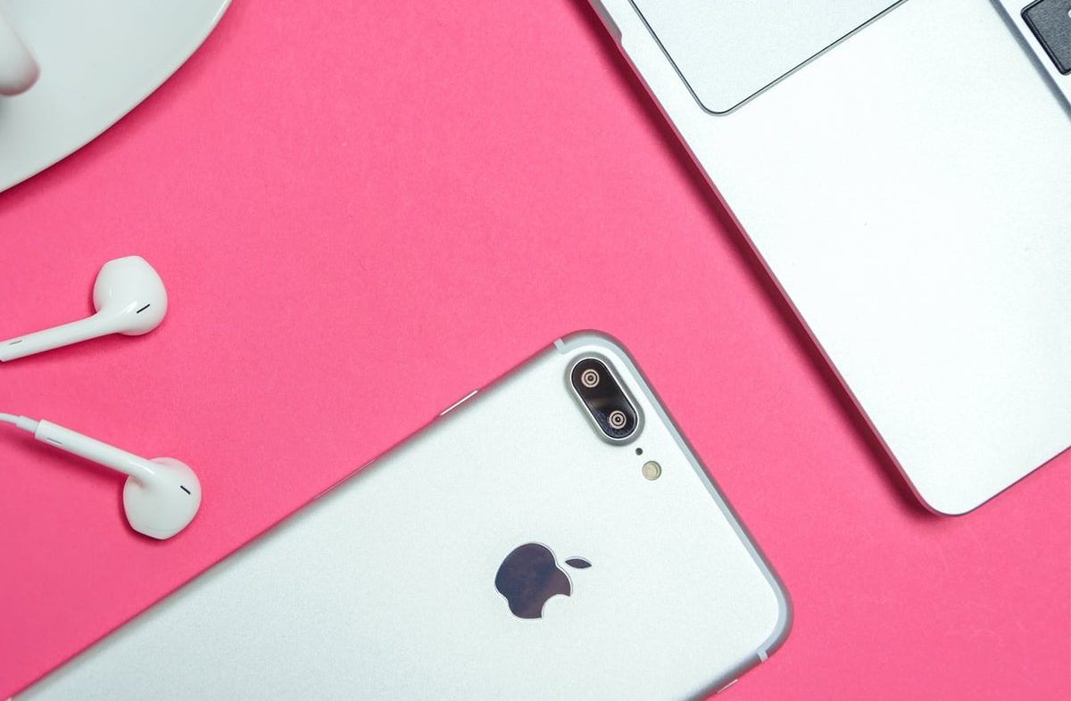 Imagem de um smartphone da Apple com um fone de ouvido