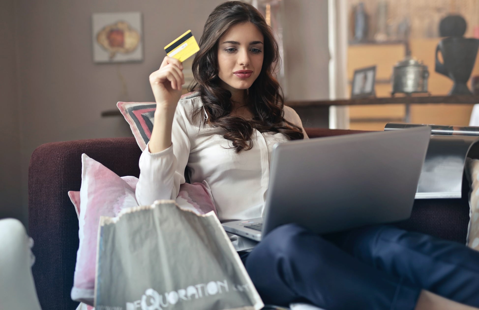 Mulher sentada no sofá compra pela internet