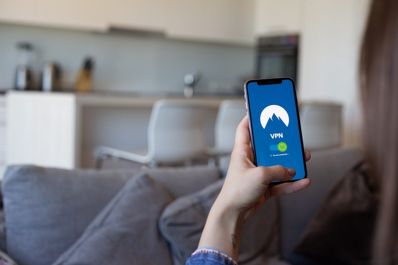 Imagem de mulher com celualr na mão com sistema Vpn instalado - jornalistas sofreram ataque no IOS Messager