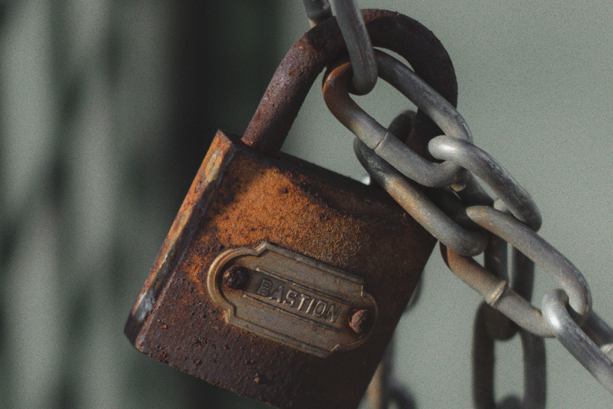 cadeado um pouco gasto pelo tempo prendendo corrente