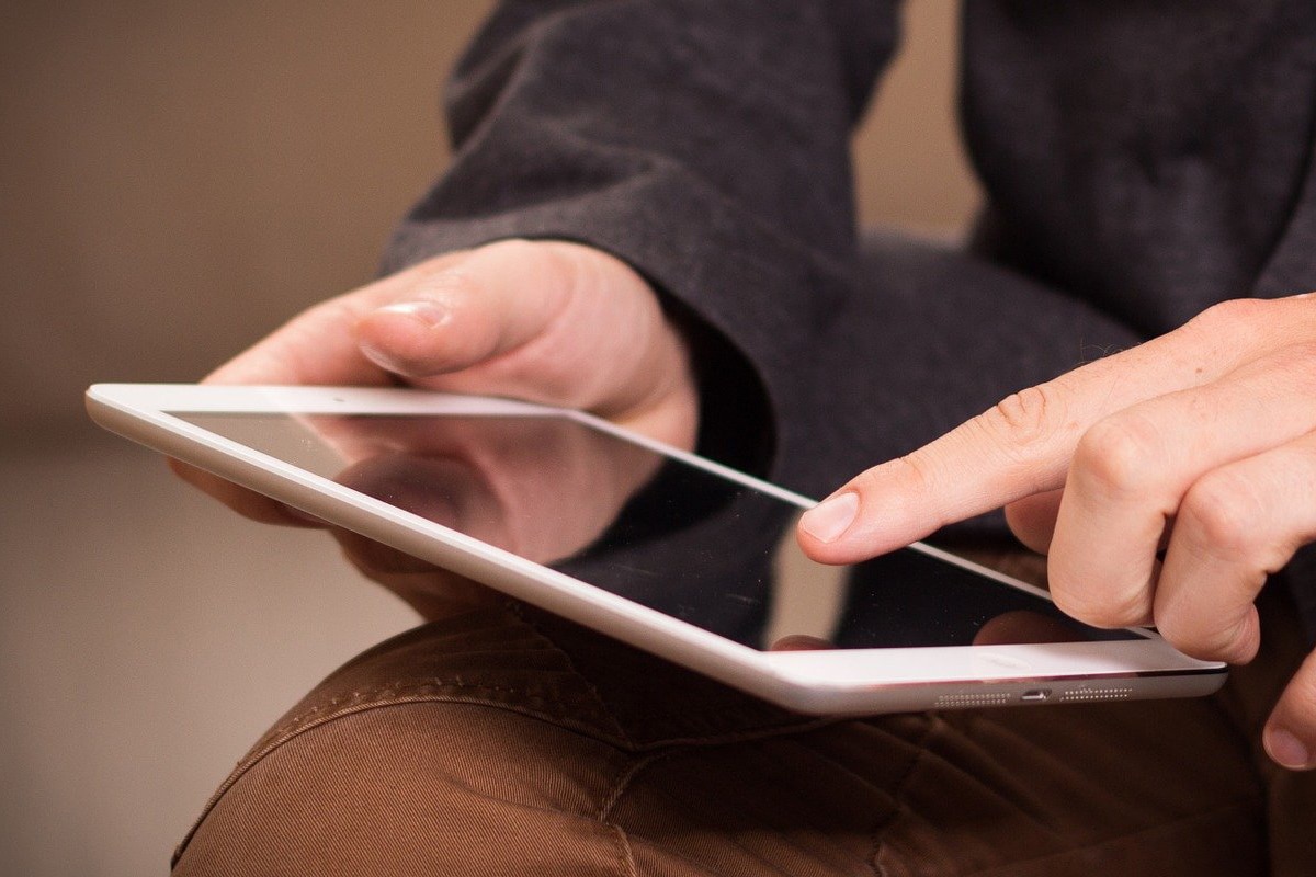 usuário tocando a tela do iPad com o dedo