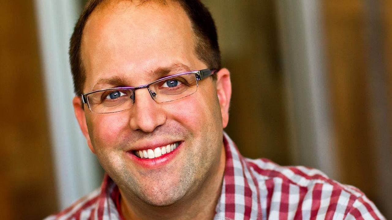 Josh Elman - Homem careca, vestindo óculos e camisa xadrez vermelha - Como novo contratado da App Store, executivo fará a ponte entre a empresa e grandes desenvolvedoras. Imagem: About Me/ Josh Elman