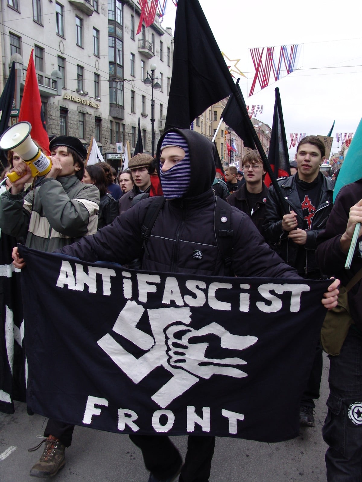 Twitter decide banir contas do movimento Antifa. Manifestante durante passeata segura bandeira antifacista