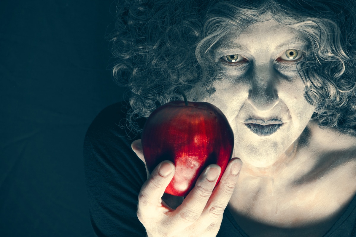 mulher segurando uma maçã, ilustrando uma bruxa