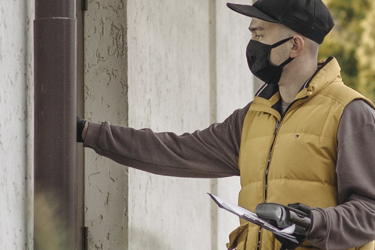 Entregador toca campainha com máscara. Ettie Plott é uma campainha que mede a temperatura dos visitantes