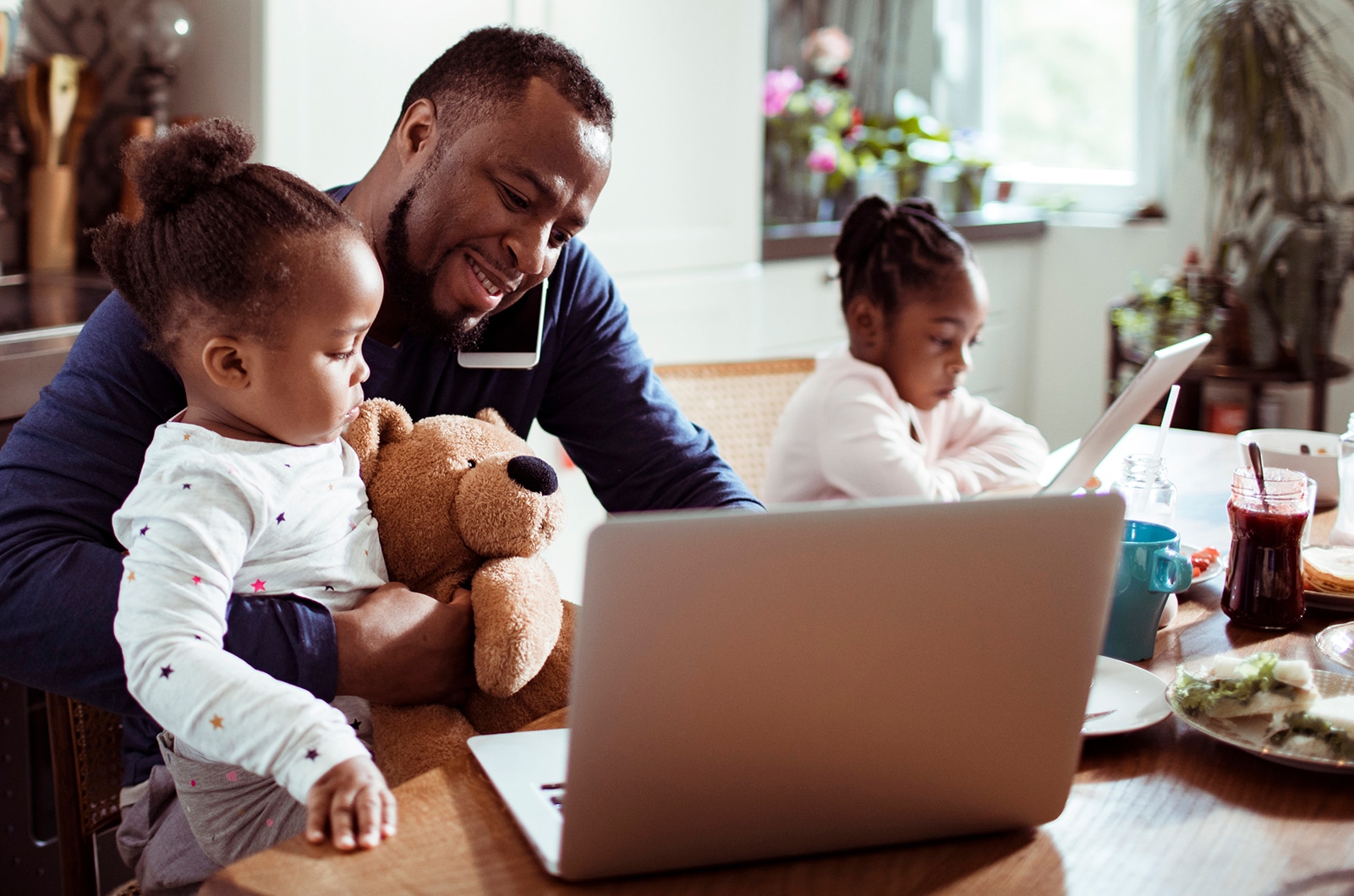 Pai trabalhando ao lado dos filhos em home office