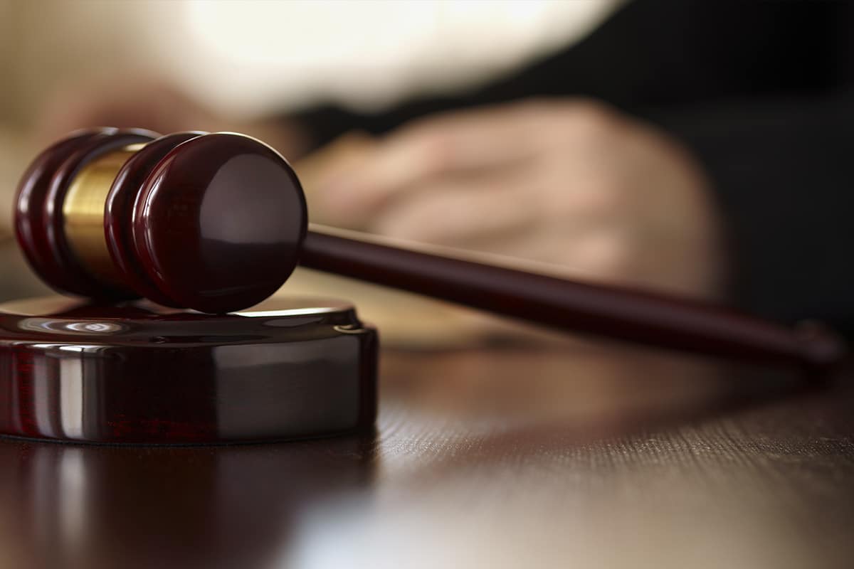 martelo e mão de um juiz, simulando ordem de Justiça