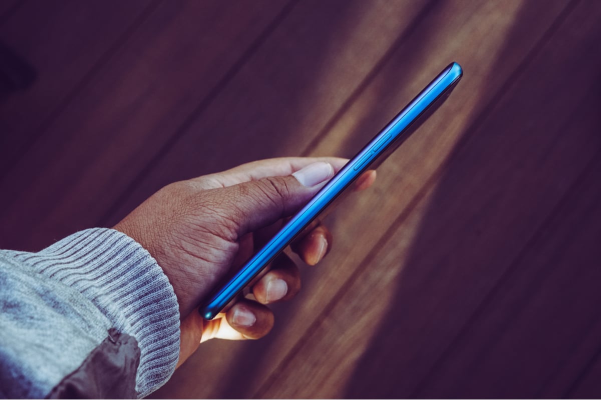 Smartphone sendo segurado mostrando a lateral