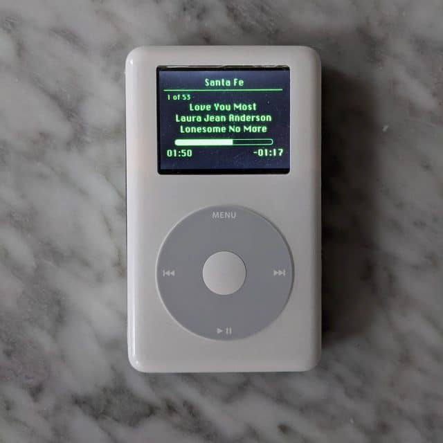 balcão com ipod mostrando música tocando em interface nas cores do spotify