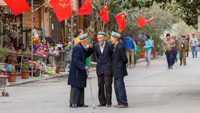três senhores da minoria Uigur conversando em Xinjiang, território chinês