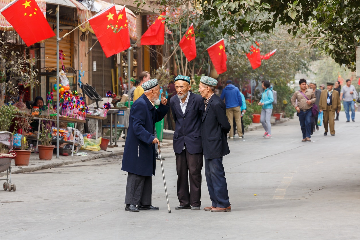 três senhores da minoria Uigur conversando em Xinjiang, território chinês