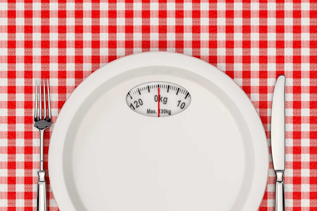 prato com medidor de balança em fundo de toalha xadrez