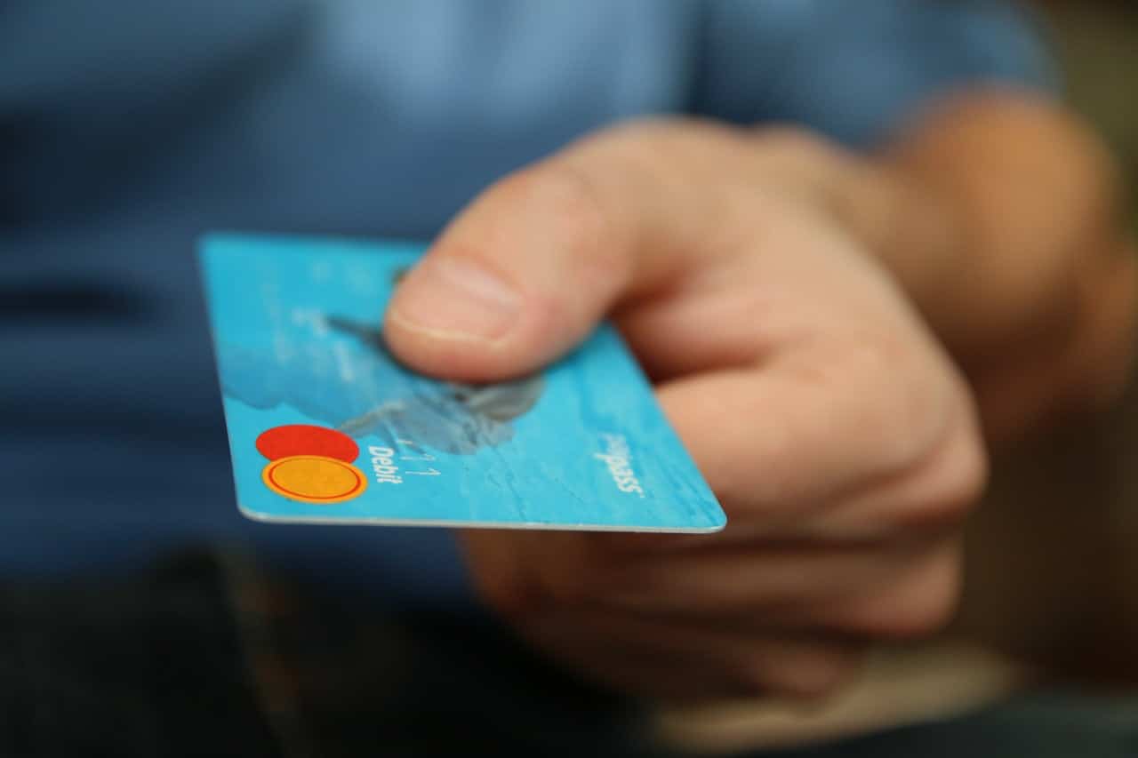 Mão masculina segura um cartão de crédito MasterCard