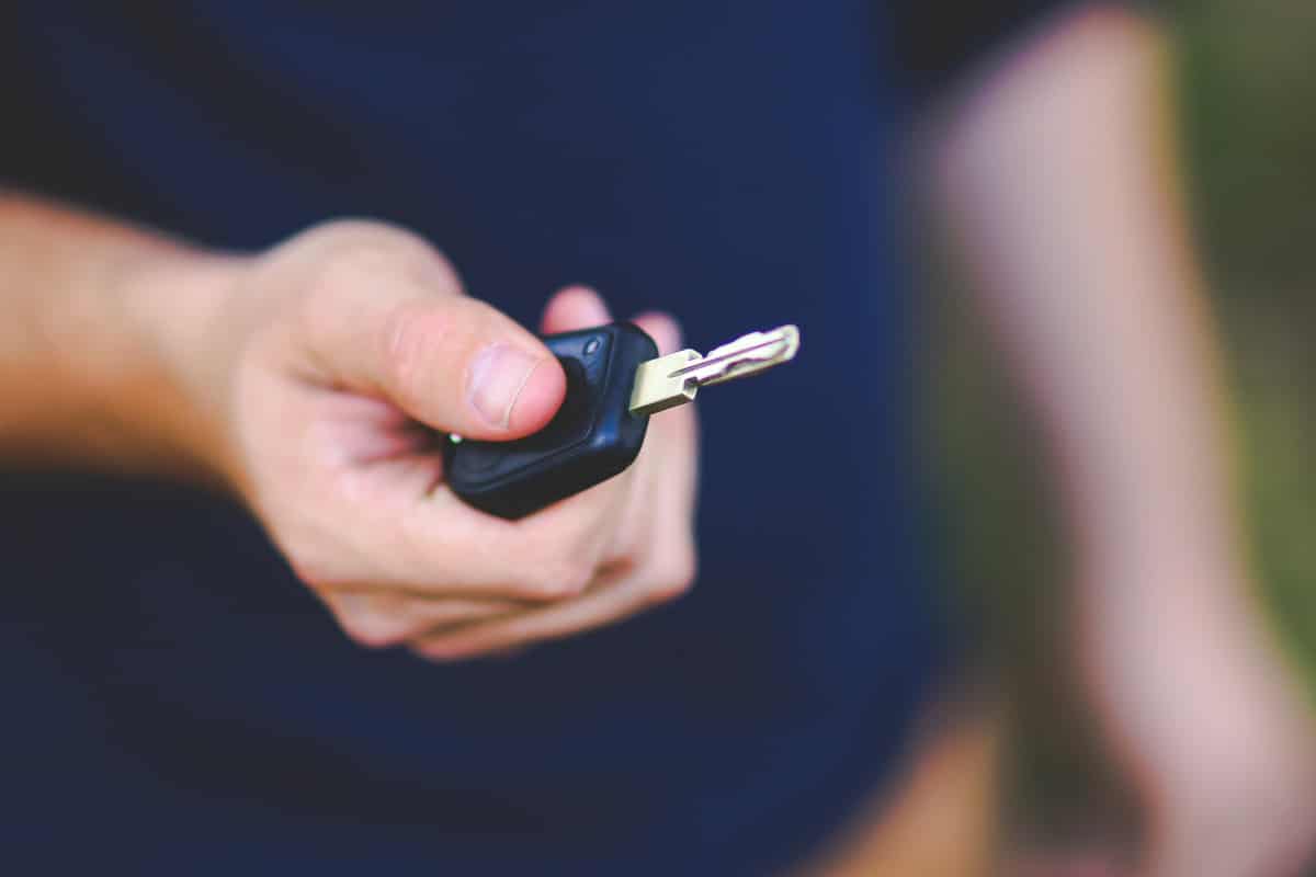 Imagem de um homem segurando uma chave de carro na mão