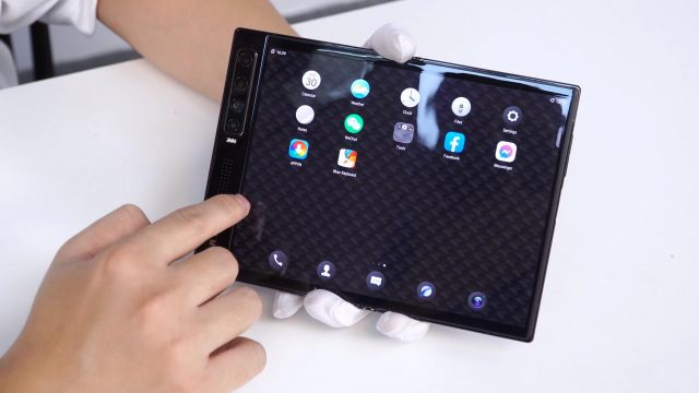 Mão segura o smartphone Vertu Ayxta Fold aberto