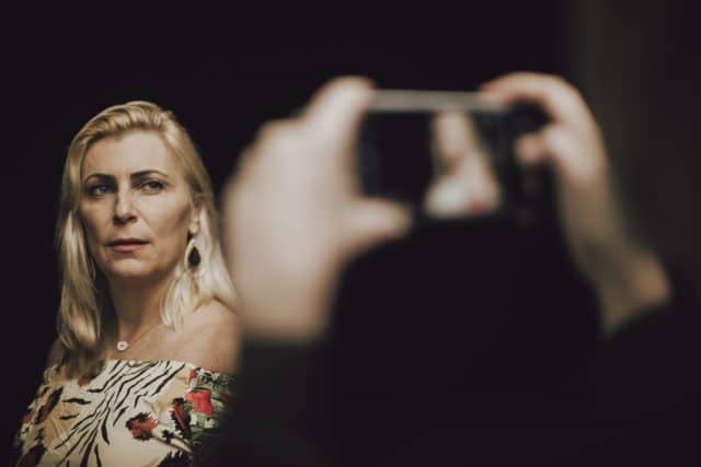 fotógrafa enquadrando mulher no celular para retrato