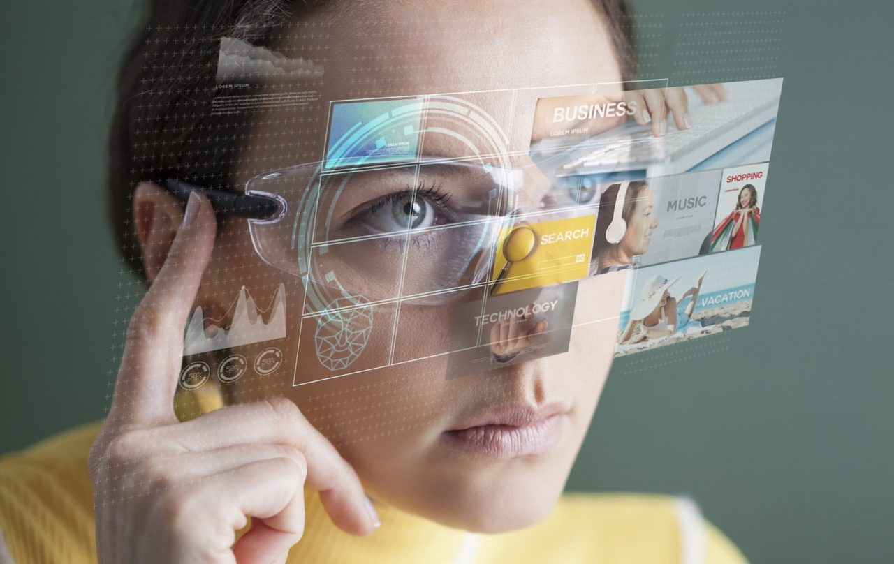 Imagem mostra uma mulher usando um tipo de óculos de realidade virtual. Os futuros Apple Glasses, da Apple, poderiam transformar imagens em hologramas para tornar o mundo virtual mais real
