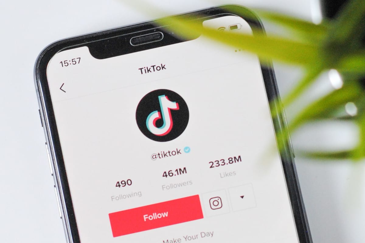 Imagem do aplicativo TikTok rodando em smartphone em cima da mesa