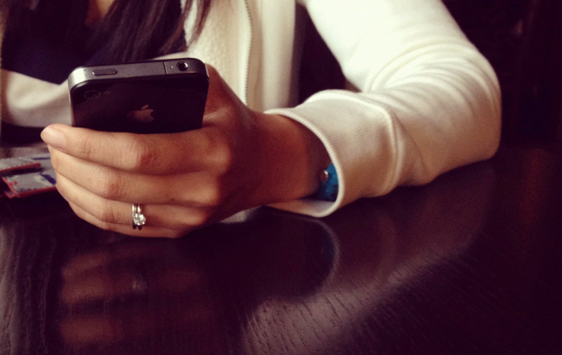 Mulher usando um iPhone da Apple com um anel