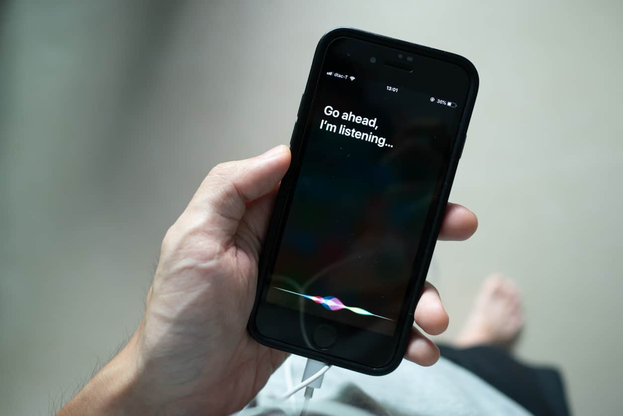 Imagem mostra mão segurando celular com a Siri em funcionamento. Apple é a que mais compra empresas de Inteligência artificial