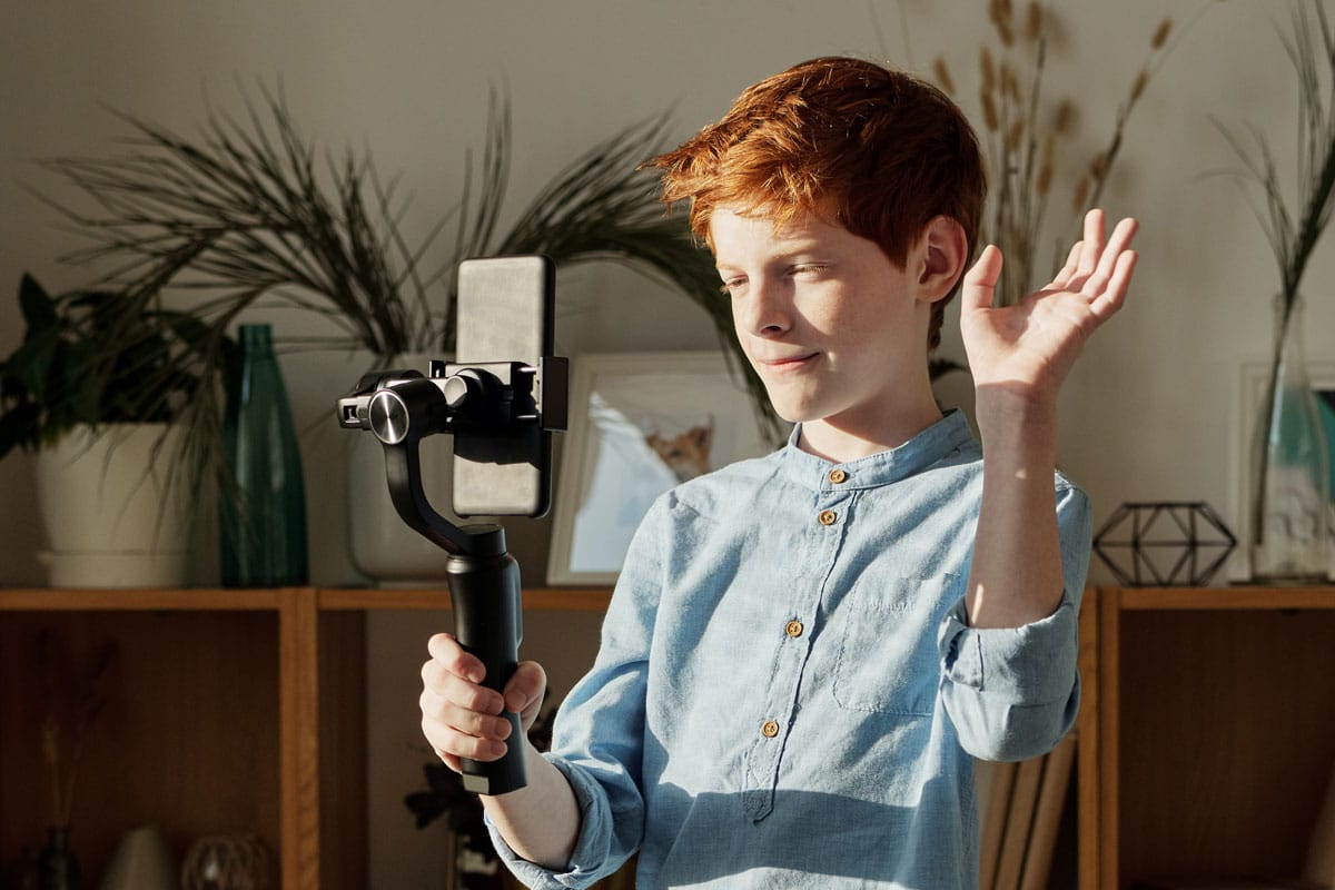 garoto fazendo live pelo celular usando pau de selfie