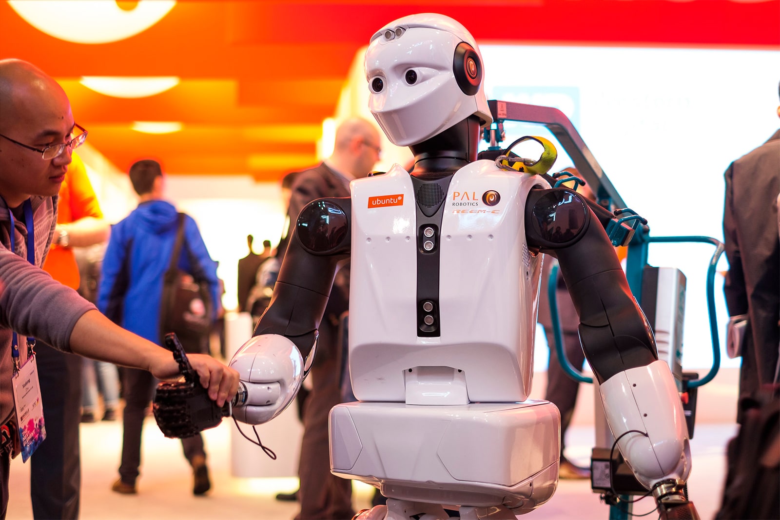 Robô cumprimenta humano em uma MWC presencial