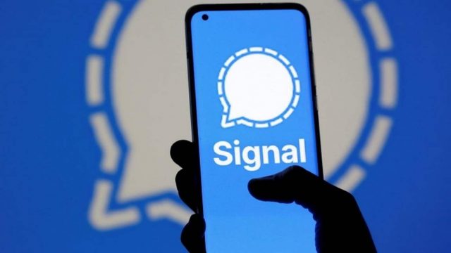 Imagem mostra mão segurando celular com o Signal, popular app de troca de mensagens, pode ter sido banido da China