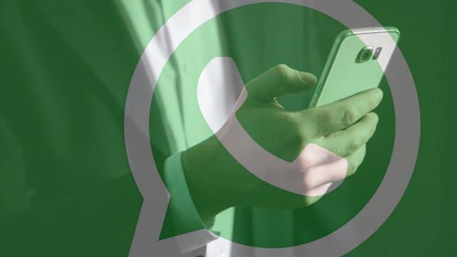 homem usando celular e imagem do logo do whatsapp
