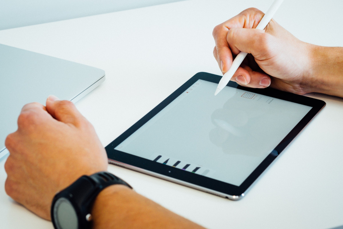 Foto de rapaz usando um iPad e uma Apple Pencil