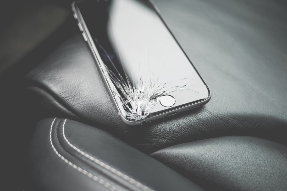 Imagem de celular quebrado no banco do carro