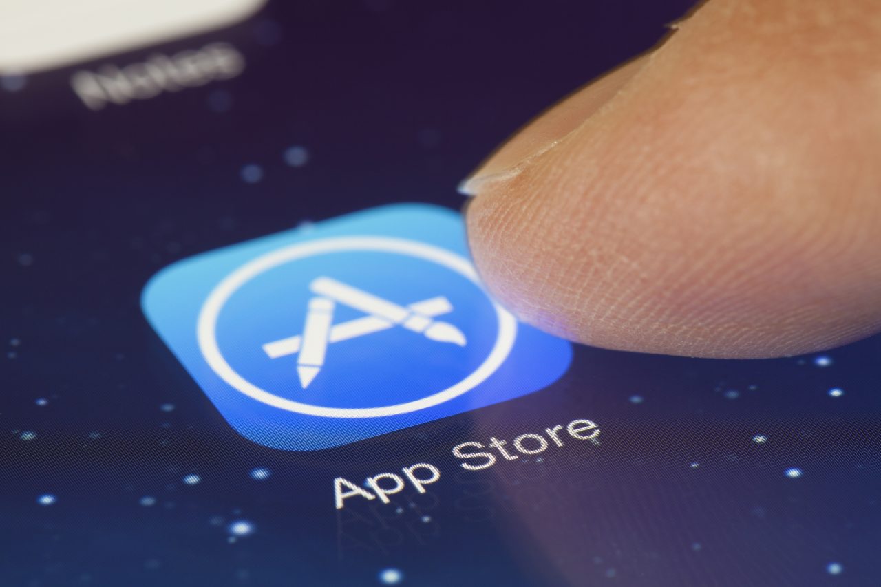 Um dedo toca o ícone da App Store, que agora tem sugestões em tempo real na busca