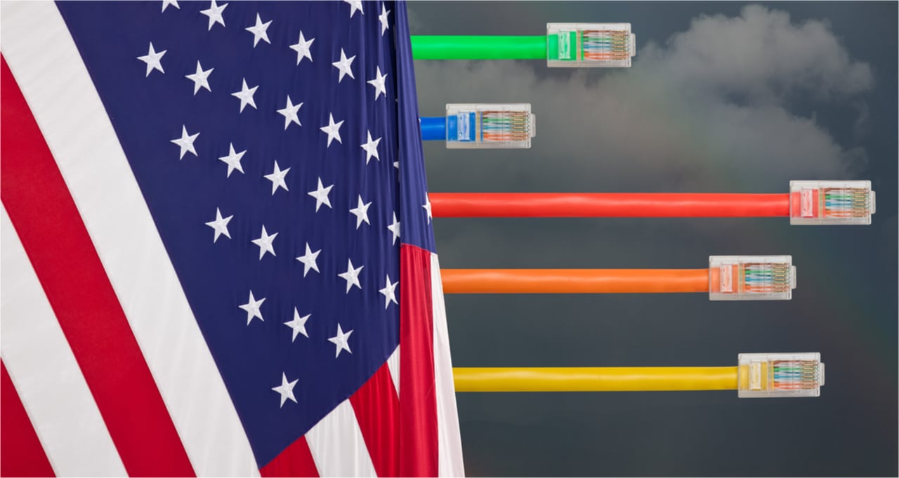 Imagem mostra a bandeira dos Estados Unidos, com cabos de internet coloridos saindo por trás dela e, ao fundo, nuvens de um tempo nublado