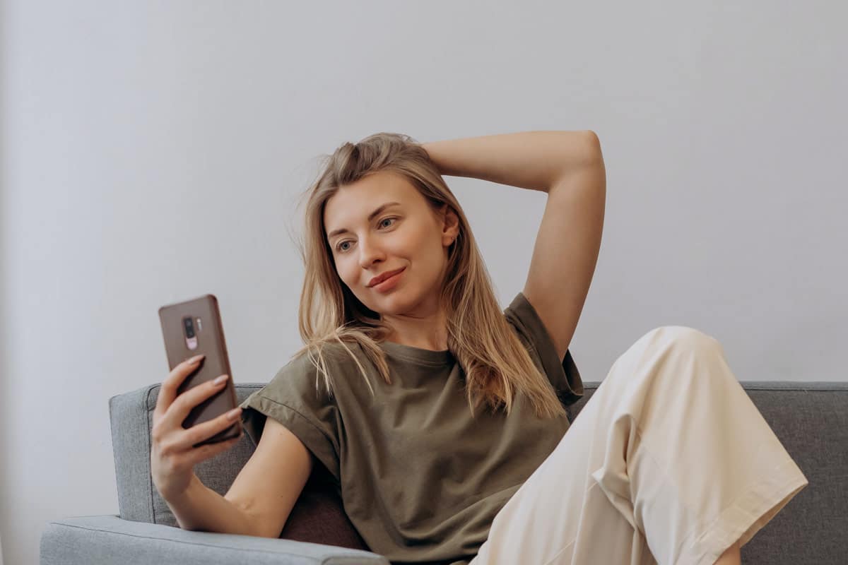 mulher tirando selfie no sofá