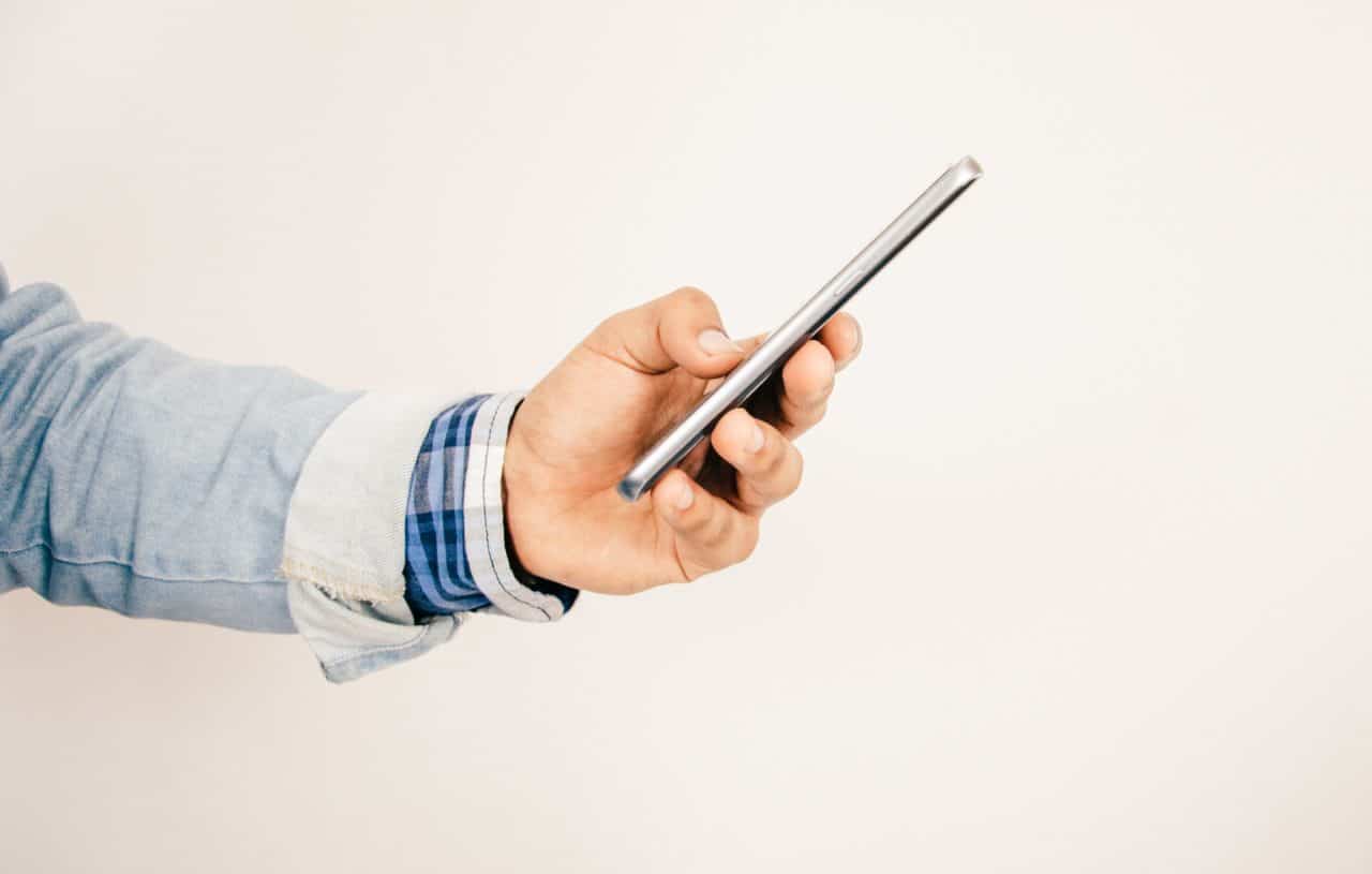 Há muitas marcas de celulares desconhecidas no Brasil, como a não identificável do smartphone que está sendo seguro por um homem na imagem