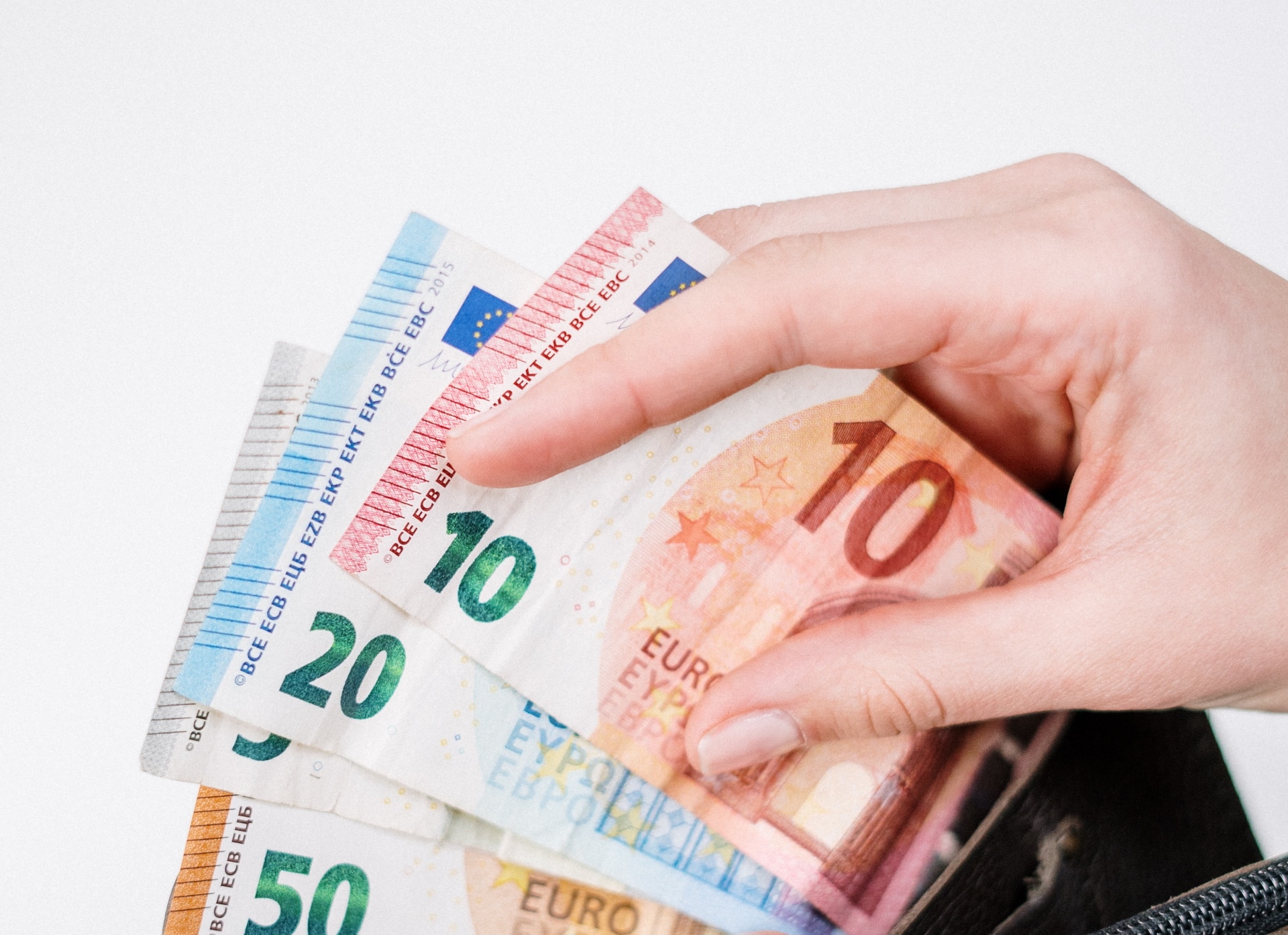 Imagem mostra pessoa abrindo carteira e pegando notas de euros, simbolizando pesada multa que o Google terá de pagar na Itália por supostas irregularidades com o Android Auto