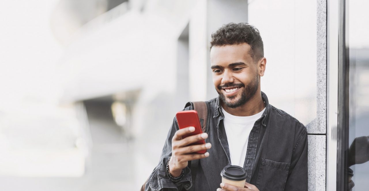 Homem segura celular, ilustração da matéria de descontos