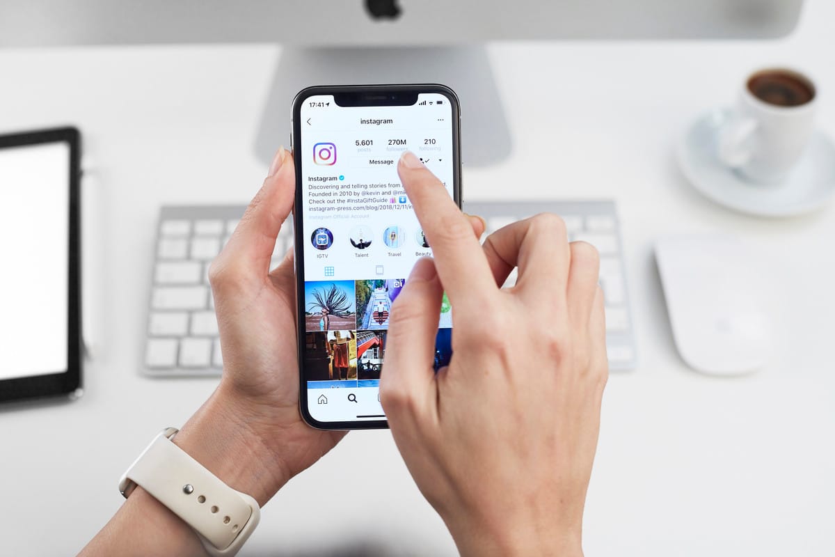 Mãos de mulher segurando um celular com o app Instagram aberto