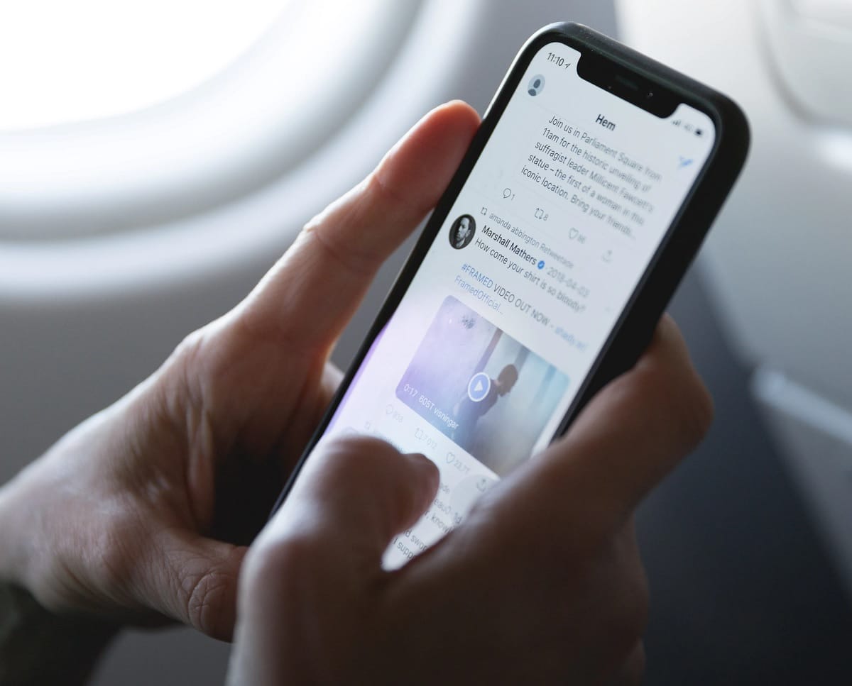 Pessoa com um smartphone em mãos com a tela do Twitter aberta