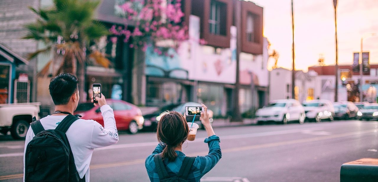 casal de turistas fotografando rua