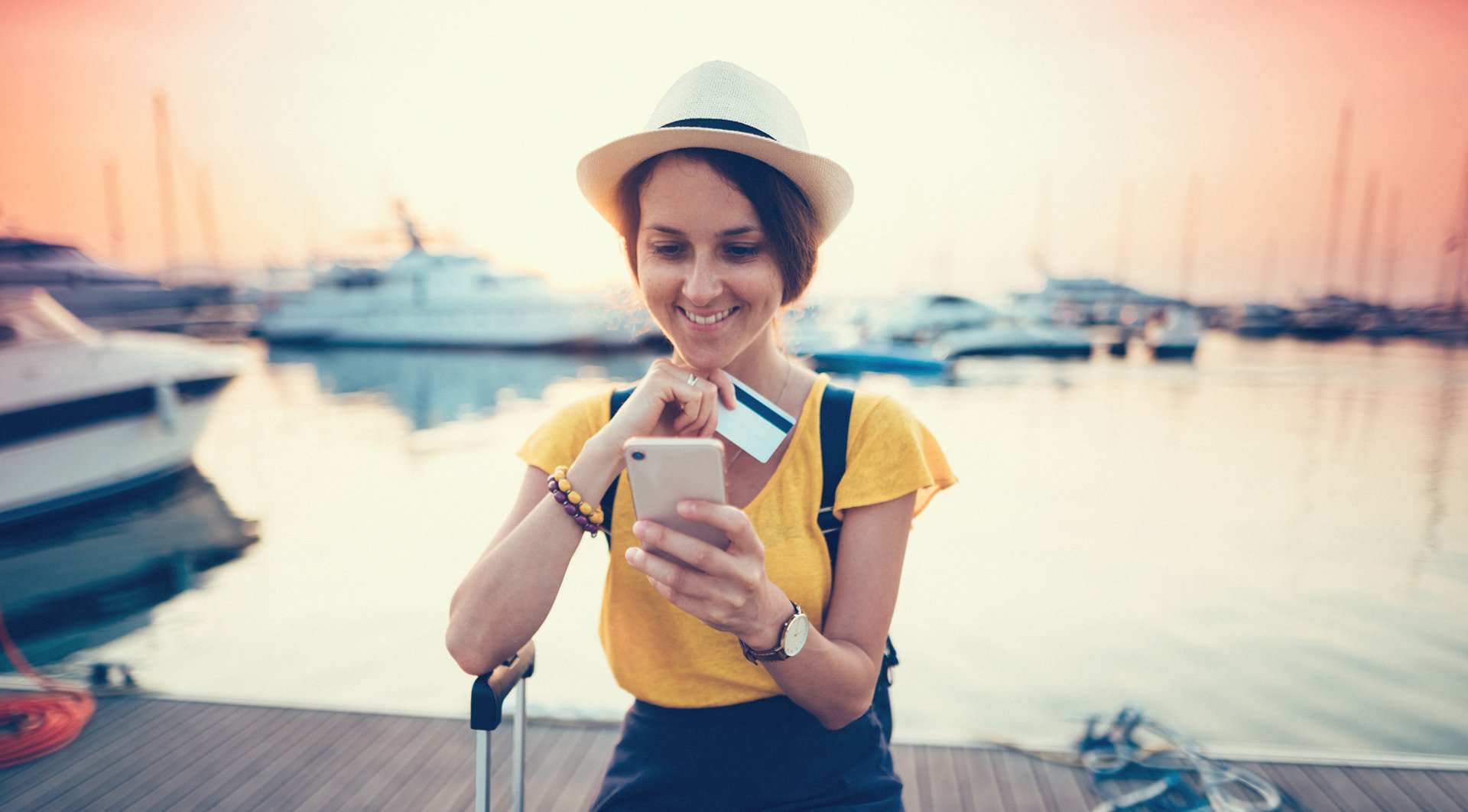 viajante na beira do cais com smartphone e cartão de crédito