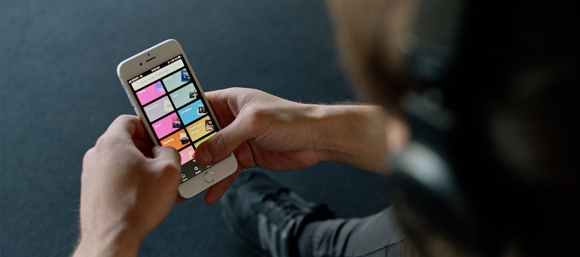 Homem com um smartphone no aplicativo do Spotify