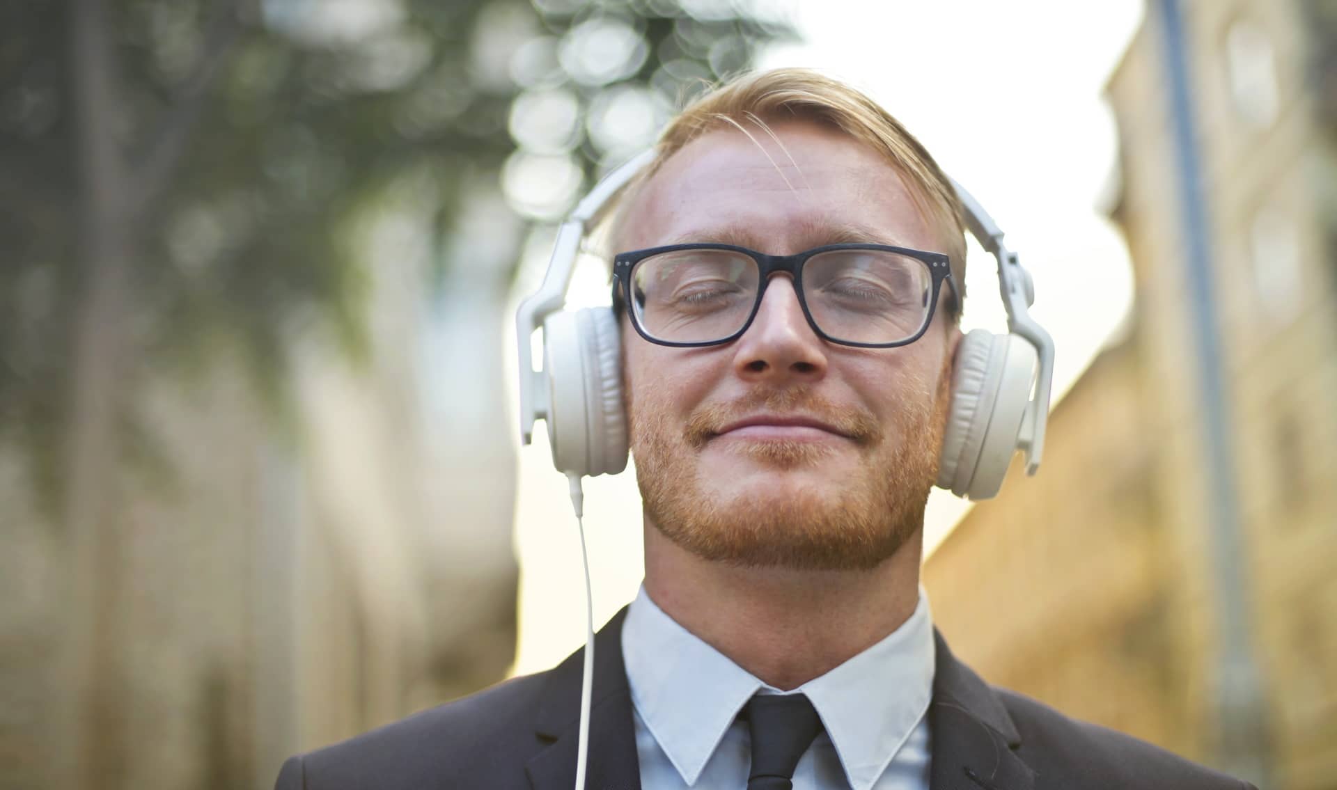 Imagem mostra homem curtindo som com fones de ouvido. Novo recurso do iOS 15 permitirá transformar qualquer som em áudio espacial com fones da Apple