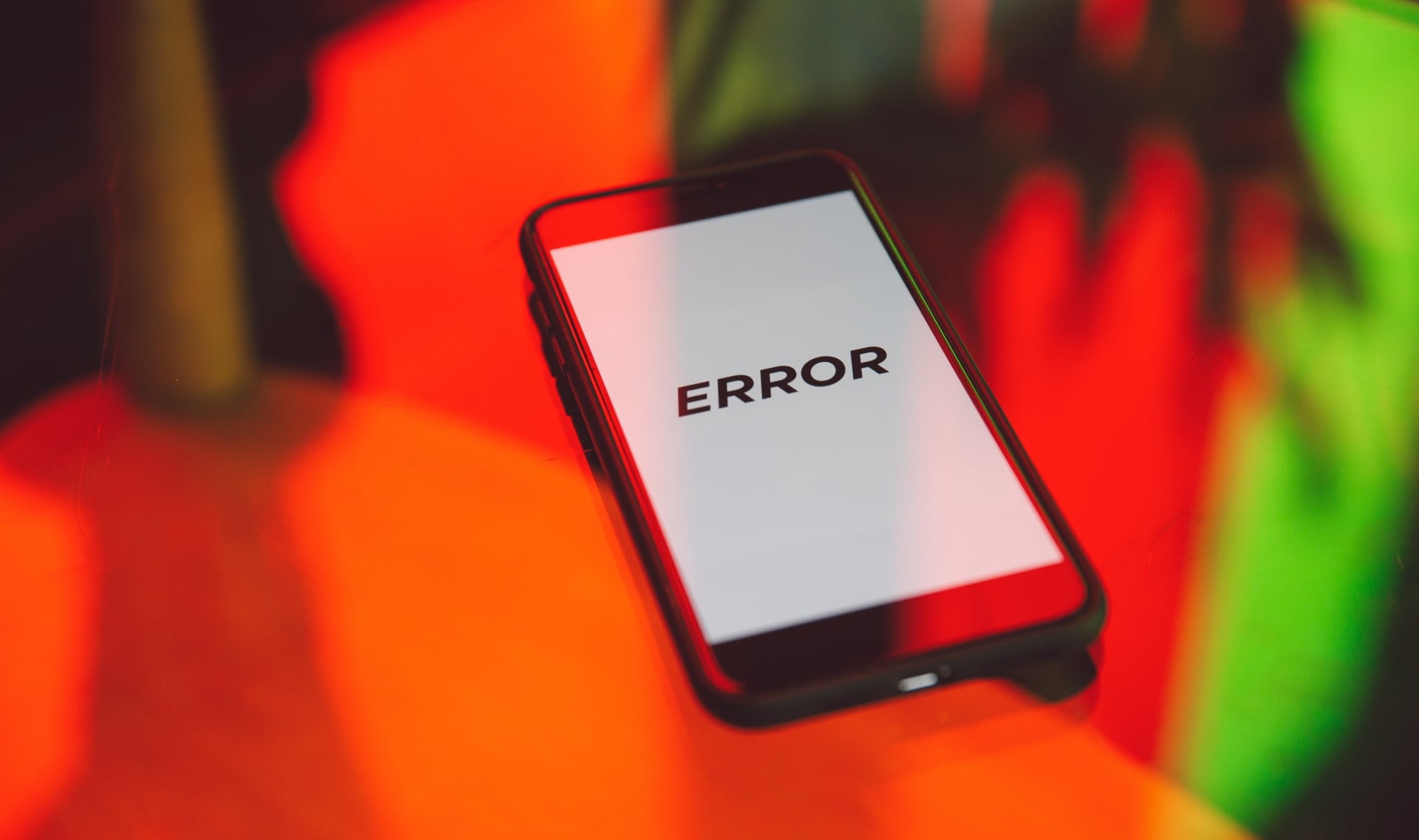 Imagem mostra celular em cima de mesa e mensagem ERROR escrita na tela, simbolizando problema que deixou sites fora do ar nesta terça