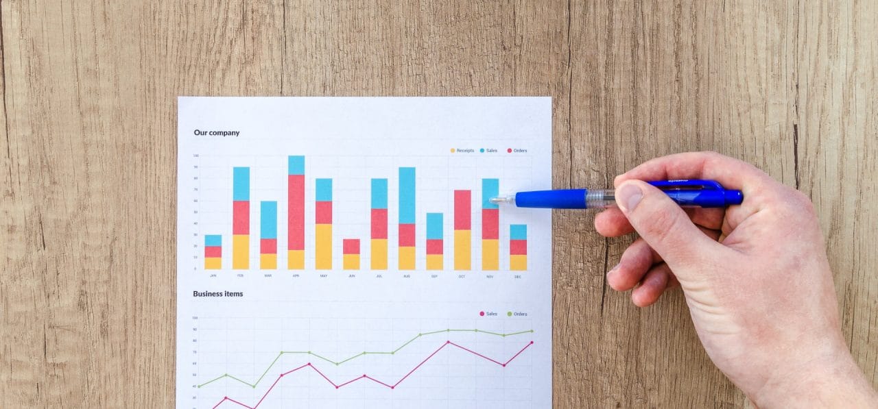 Imagem mostra pessoa apontando para gráficos, que podem ilustrar o crescimento esperado para o mercado de celulares em 2021