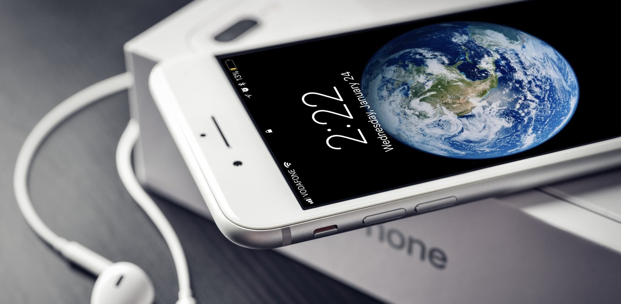 Imagem de um iPhone que roda apps em cima da caixa