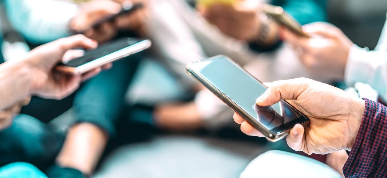 Grupo de pessoas utilizando aparelhos eletrônicos