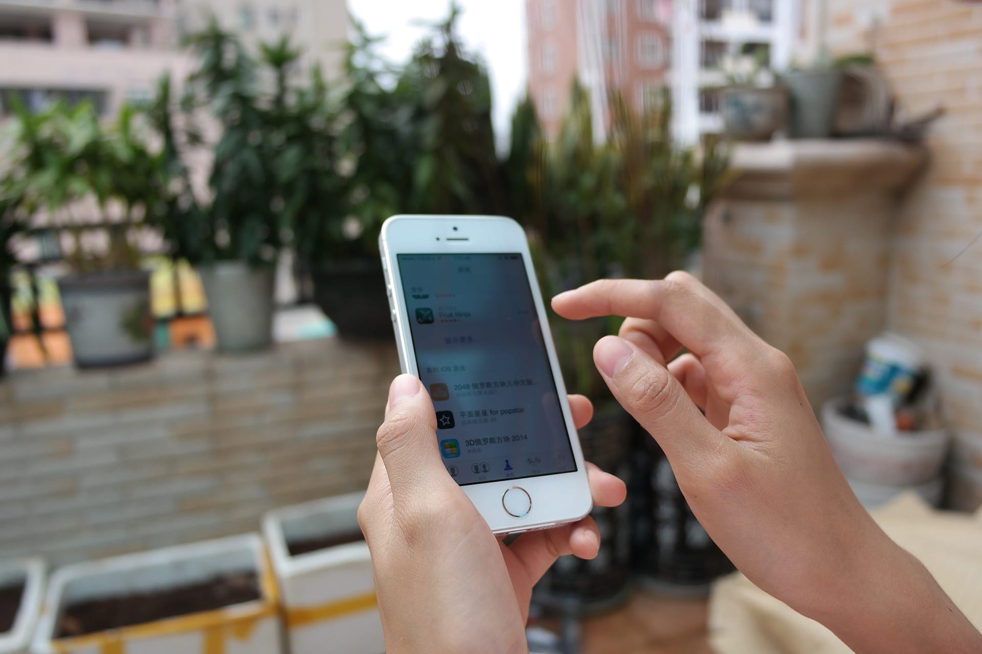 Imagem mostra pessoa mexendo no iPhone 5s, um dos modelos que receberão a nova atualização do iOS 12