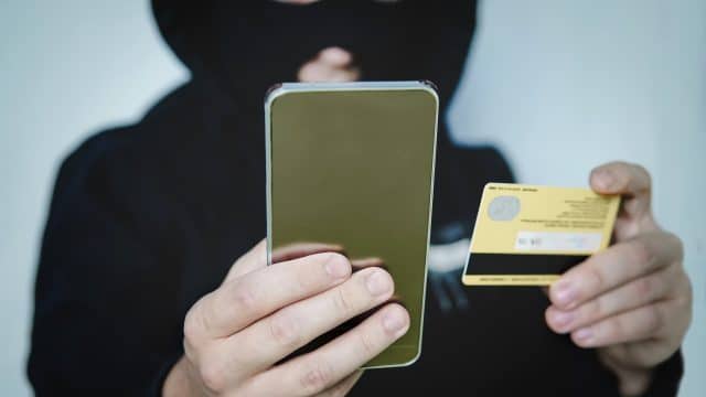 Ladrão com cartão e celular